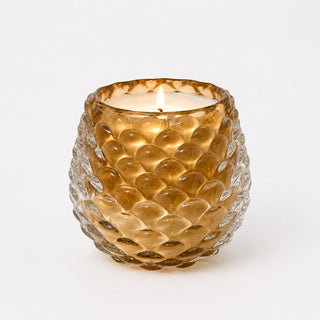 Bougie parfumée Pomme de pin, verre ambré moulé en écailles, allumée